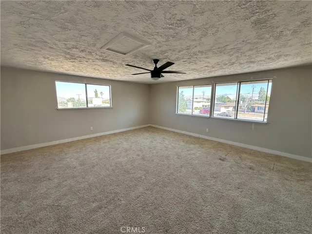 Bonus– Spacious primary suite featuring plush carpeting, a ceiling fan, and multiple windows that bring in abundant natural light while creating an open, airy feel.