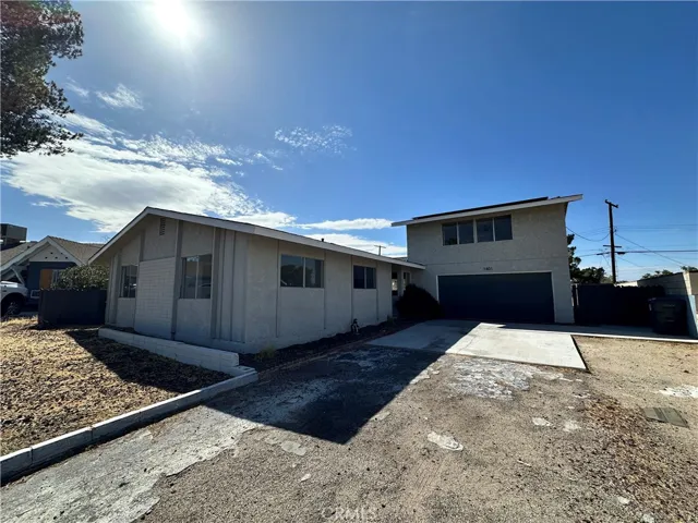 Front Exterior – Distinctive exterior with extended driveway access and attached garage, offering plenty of parking and a welcoming arrival experience.