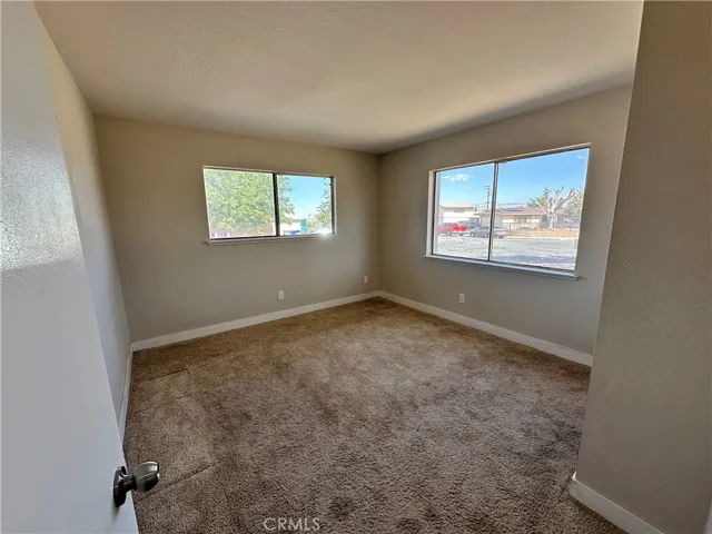 Secondary Bedroom – Comfortable secondary bedroom with plush carpeting, neutral tones, and multiple windows that create a bright and inviting atmosphere.