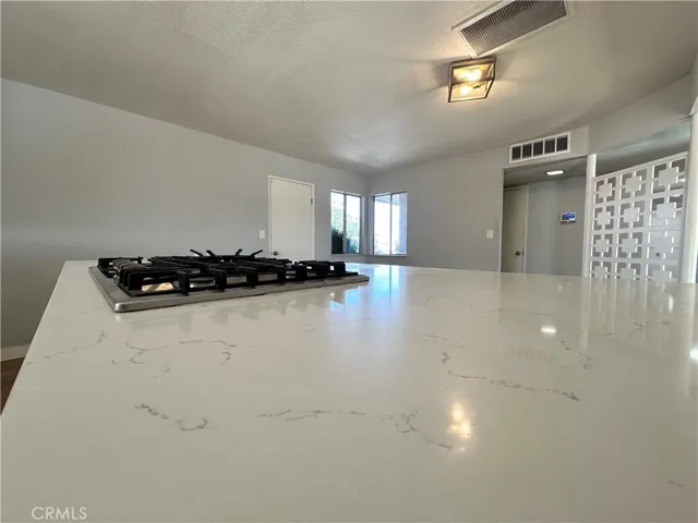 Kitchen Detail – Oversized center island with quartz-style countertops and built-in gas cooktop provides an ideal space for meal preparation, casual dining, and entertaining.