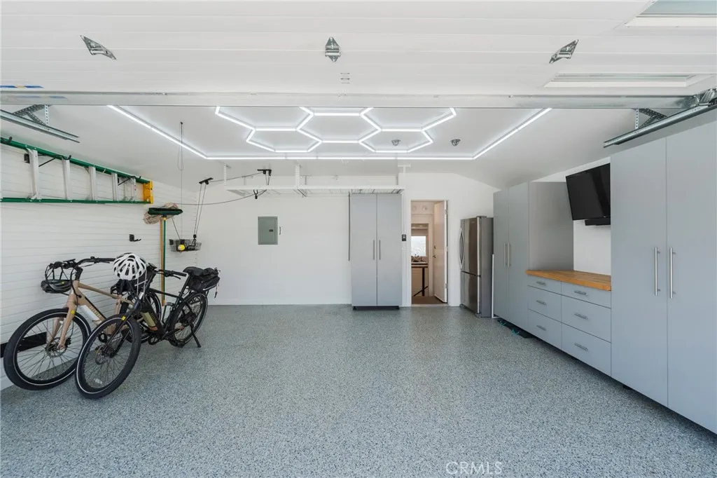 Garage with custom cabinets, mini split A/C, EV charging, expoxy floors.