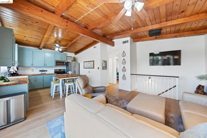 Vaulted wood-finish ceiling with exposed beams and ceiling fans