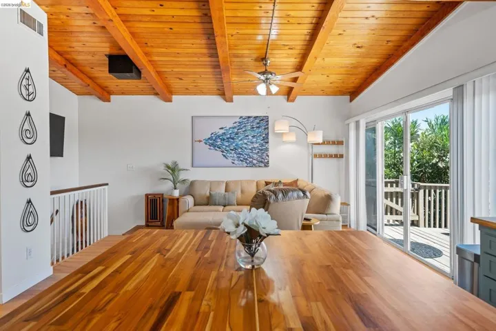 Warm wood-finish ceiling with exposed beams and a ceiling fan