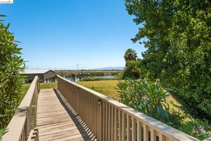 Wood-plank walkway leading to a waterfront property with a boathouse