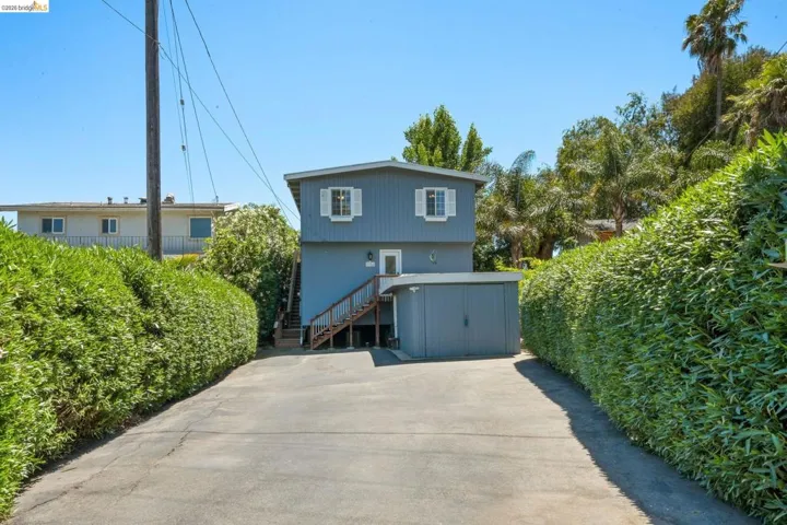 Two-story residence featuring a gray exterior with white window shutters
