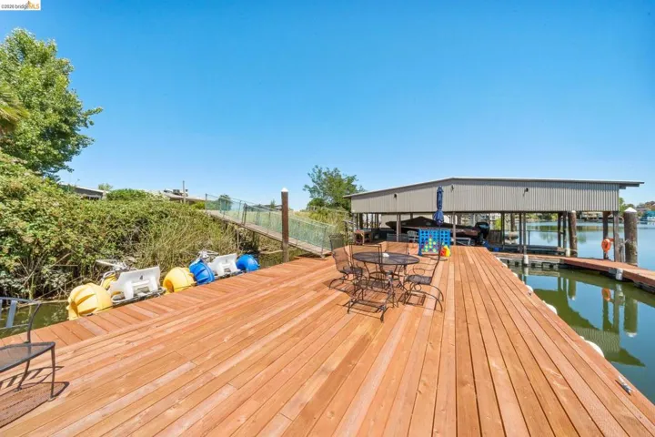 Wood-plank dock featuring a built-in boat house, covered boat slips, and direct water access