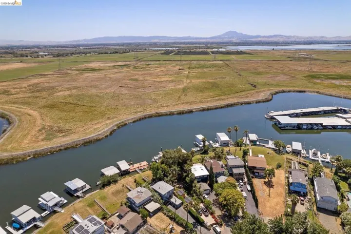 Aerial perspective showcasing waterfront properties, a marina with covered slips, and a natural waterway