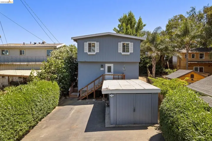 Two-story residential structure featuring a gray exterior siding and white window shutters