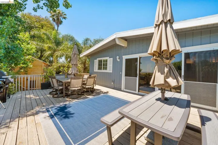 Expansive wood deck with a built-in railing, offering multiple seating areas