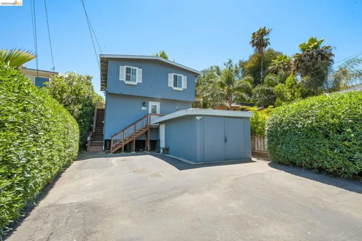 Two-story property featuring a blue exterior with white window shutters