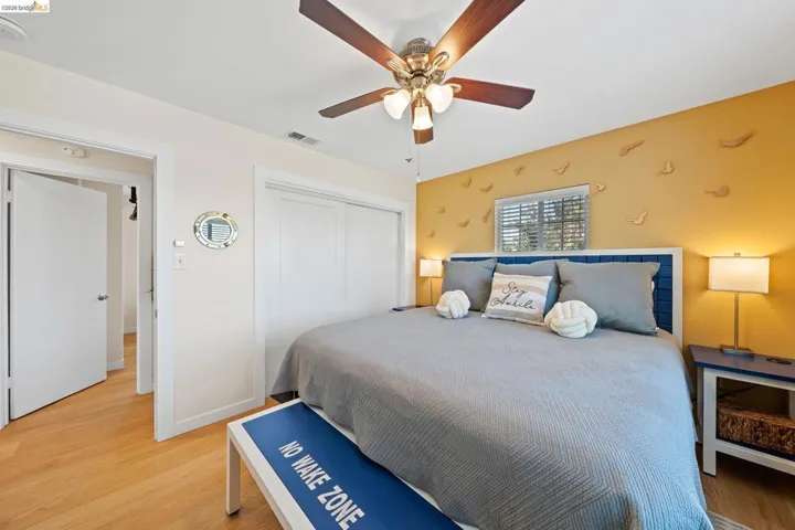 Light wood-finish flooring with a ceiling fan featuring wood-tone blades