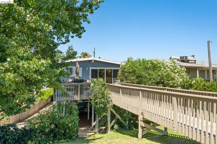 Elevated wood deck with railing and direct access to a separate wooden walkway
