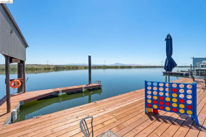 Expansive waterfront deck featuring wood-finish planks and direct water access