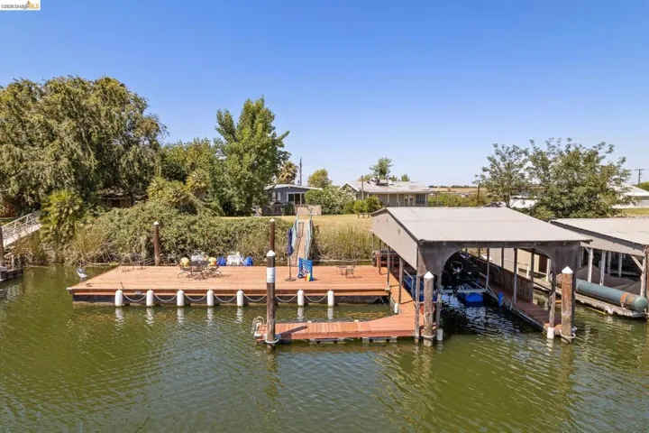 Private dock with a covered boat slip, extended sun deck, and additional floating dock