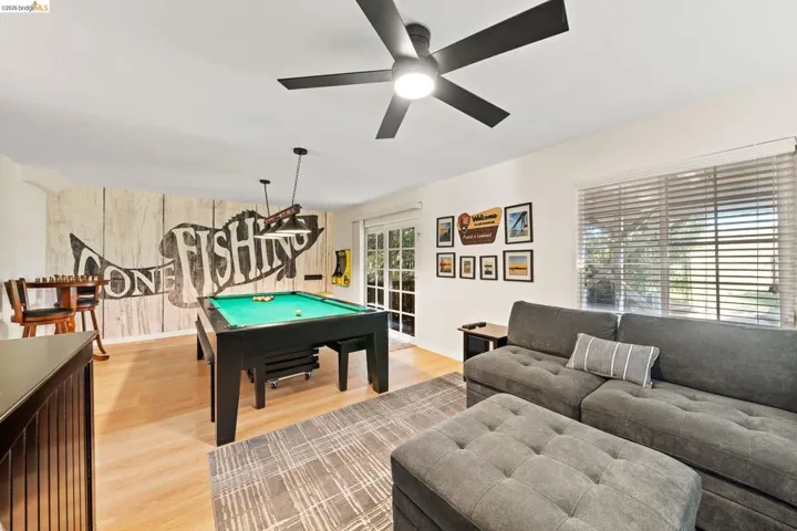 Spacious room featuring light wood-finish flooring and a distinctive accent wall