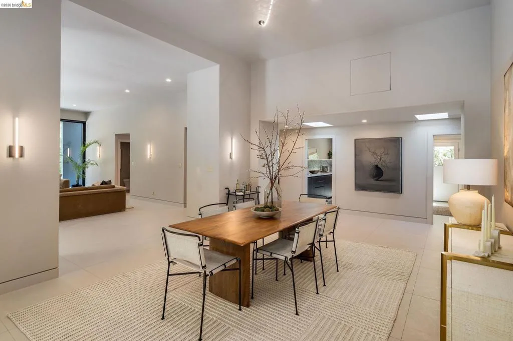 Open-concept interior featuring light-toned flooring, high ceilings, recessed lighting, and wall-mounted sconces