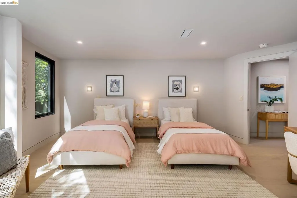 Spacious room featuring light wood-finish flooring, recessed lighting, and a large window with black trim