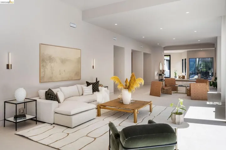 Spacious living area featuring high ceilings, recessed lighting, neutral wall tones, and light-toned flooring