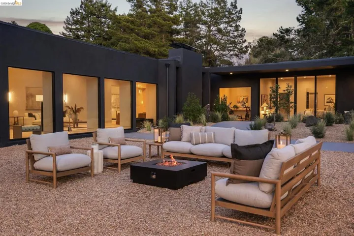 Spacious exterior courtyard featuring a gravel ground cover and a built-in fire pit