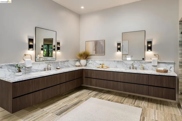 Floating wood-finish vanity with two rectangular undermount sinks, flanked by rectangular framed mirrors