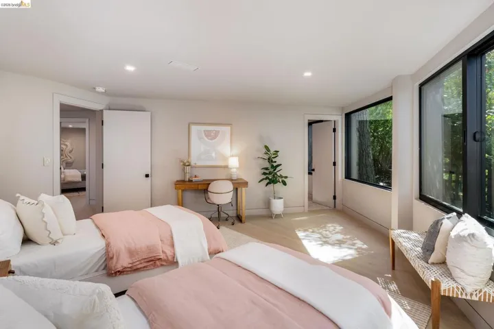 Light-toned wood-finish flooring complements the neutral wall color in this room, featuring recessed lighting and a doorway opening to an additional space