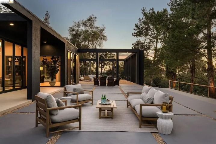 Expansive outdoor patio area featuring large format pavers, gravel accents, and a perimeter railing