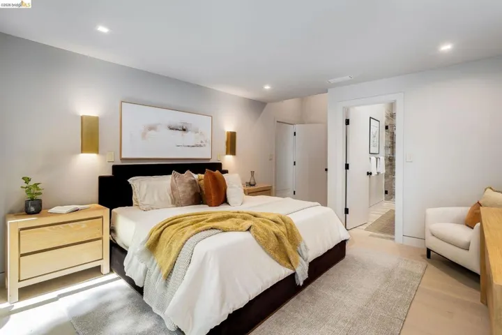 Bedroom featuring light-tone wood-finish flooring, recessed lighting, and wall-mounted sconces