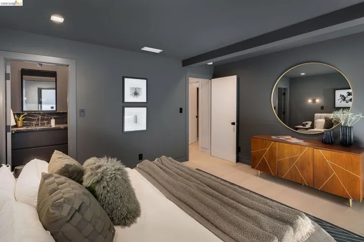 Spacious room featuring light wood-finish flooring, dark accent walls, and recessed lighting