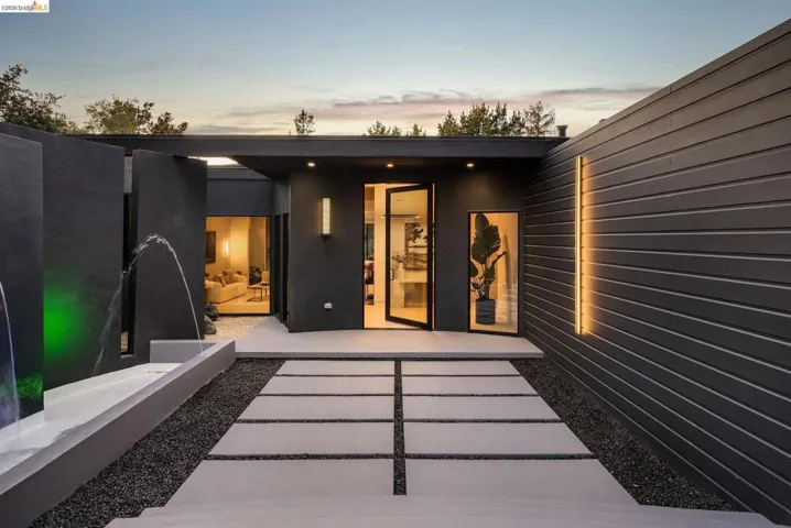 Contemporary exterior featuring dark horizontal siding and a clean-lined concrete walkway