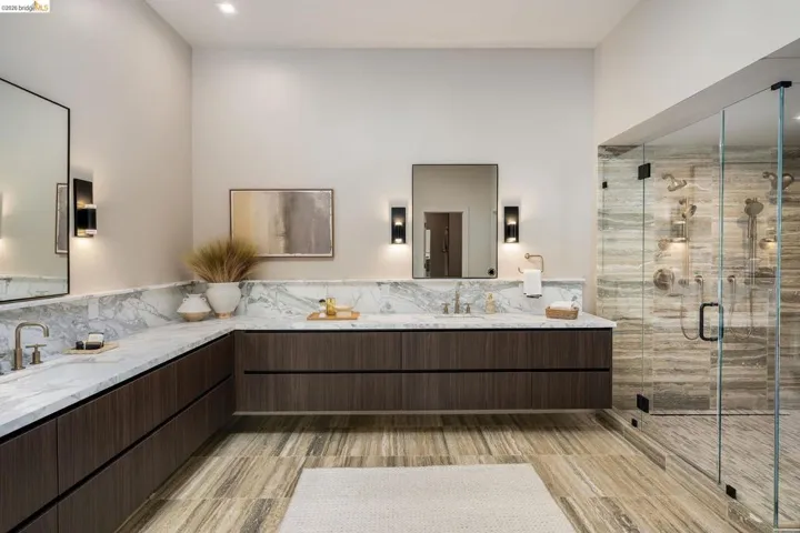 Spacious bathroom featuring a dual vanity with stone countertops and dark wood-finish cabinetry