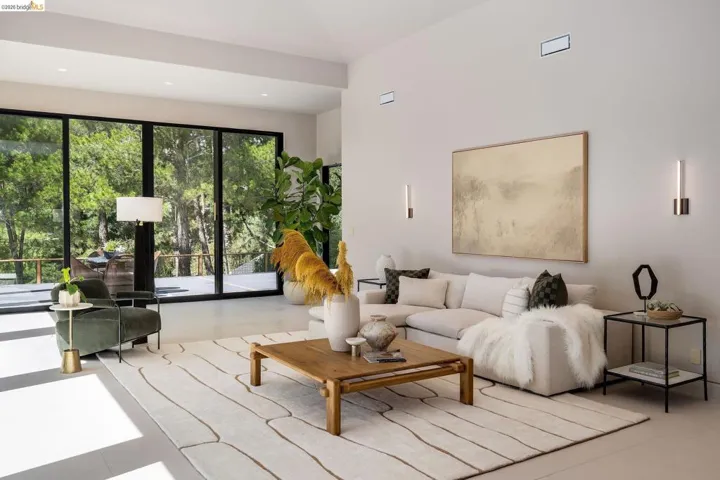 Spacious interior featuring floor-to-ceiling windows, high ceilings, recessed lighting, and wall-mounted sconces