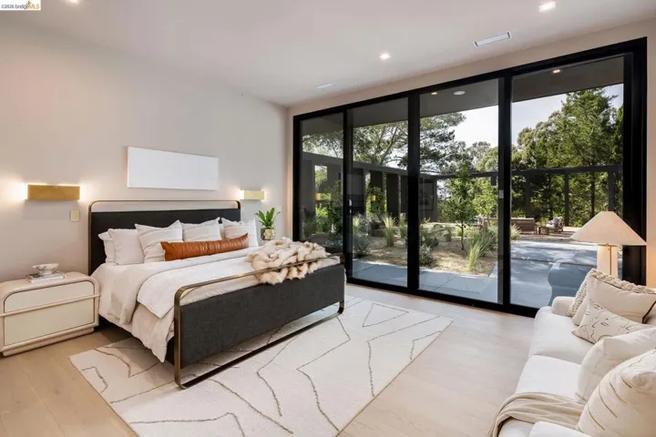 Bedroom featuring wood-finish flooring, recessed lighting, and a full wall of black-framed sliding glass doors