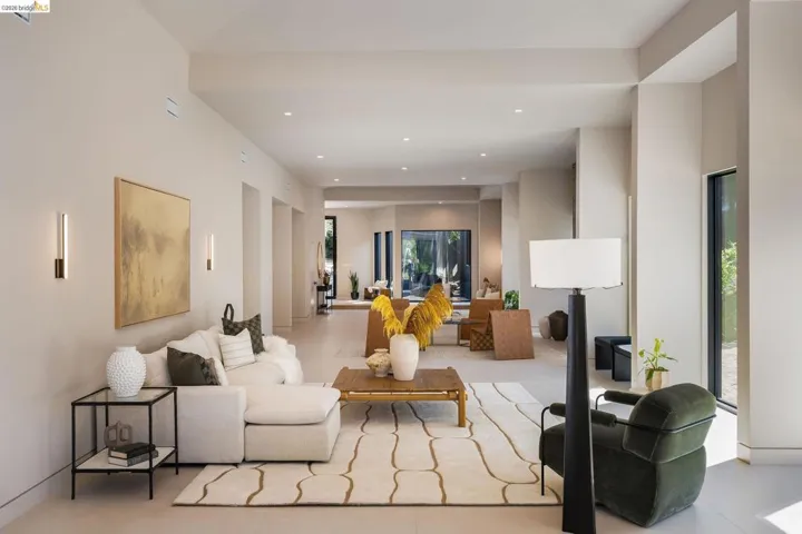 Spacious living area featuring high ceilings, recessed lighting, and large windows