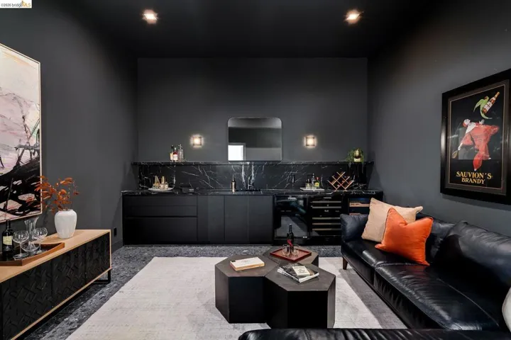 Entertainment space featuring built-in cabinetry with a black marble countertop and backsplash