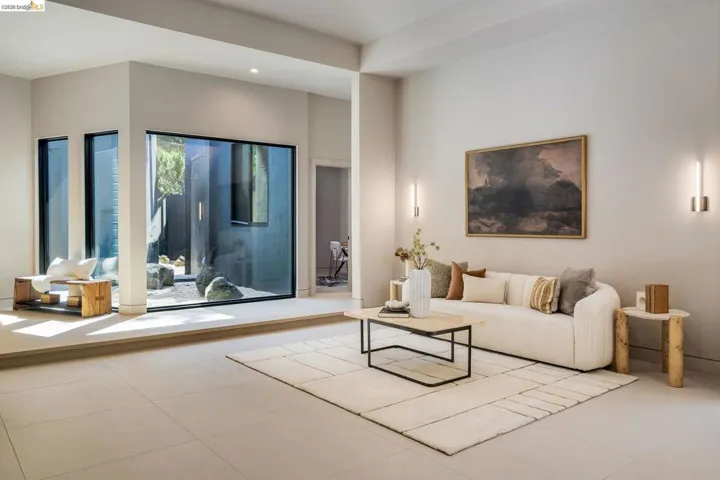Spacious living area featuring large format tile flooring and a minimalist aesthetic