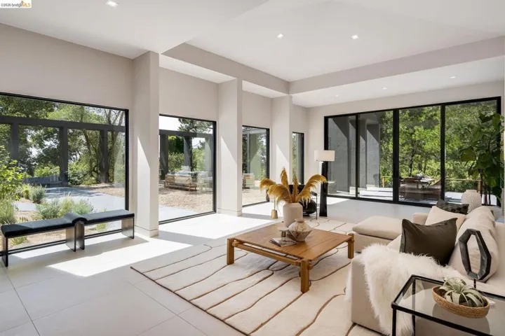 Spacious living area featuring large format tile flooring, recessed lighting, and expansive floor-to-ceiling windows