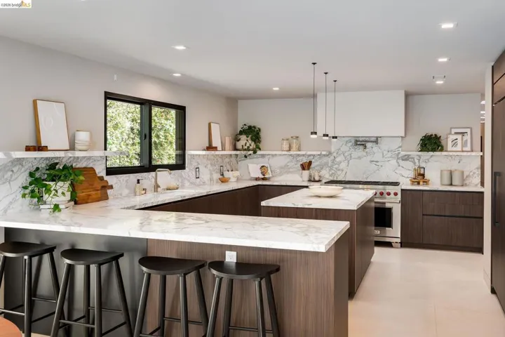 Modern kitchen featuring dark wood-finish cabinetry, white stone countertops, and a full-height stone backsplash