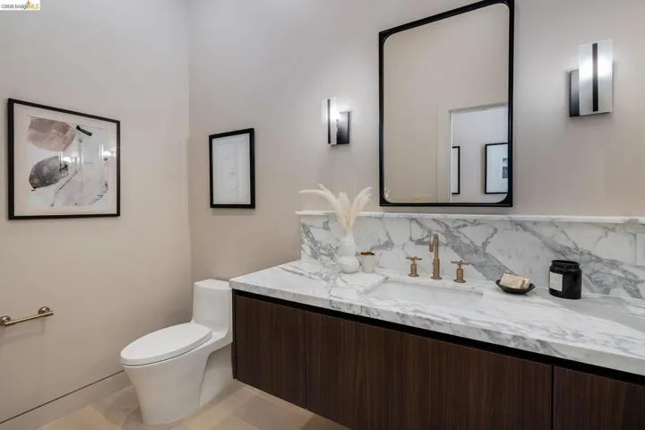 Floating wood-finish vanity with a stone countertop and integrated sink basin
