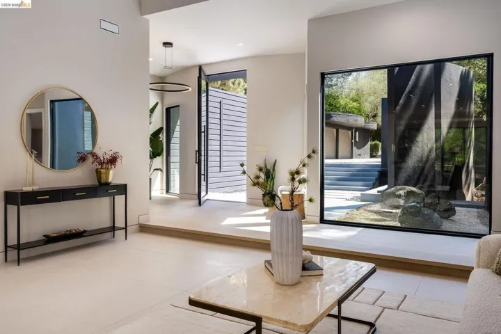 Spacious entry foyer featuring light-toned tile flooring and a double-height ceiling