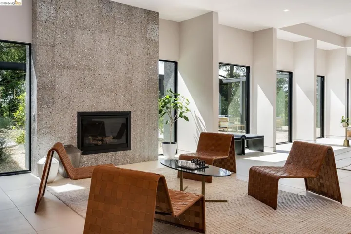 Living area featuring a floor-to-ceiling fireplace with a textured stone finish and a dark metal firebox