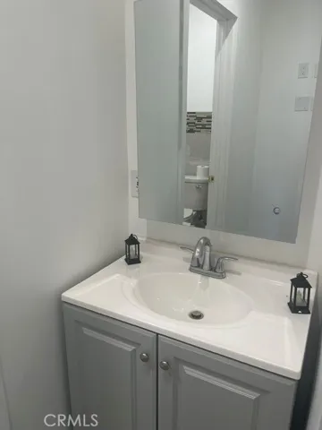 Vanity and nice mirror in bathroom.