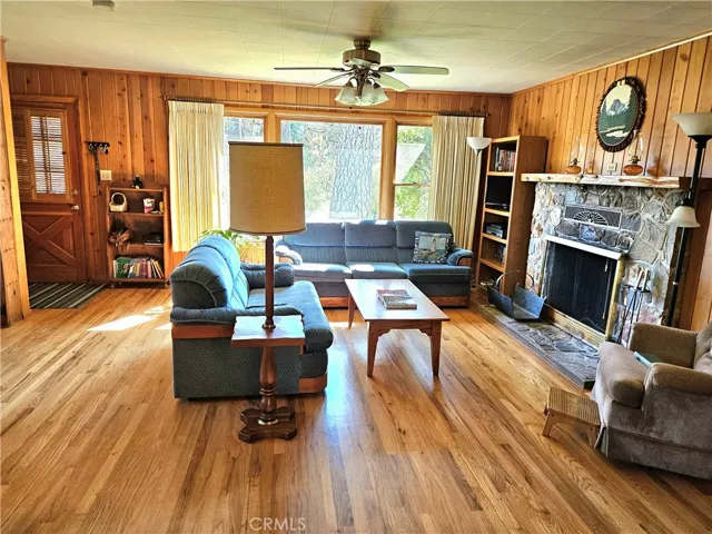 Living room is warm and inviting. Large stone fireplace, good views of landscaped yard.