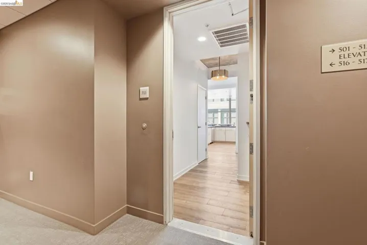 Entryway featuring light wood-finish flooring, neutral painted walls, and a contemporary ceiling fixture