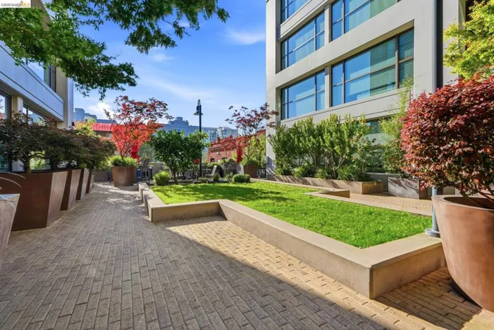 Manicured outdoor space featuring paver pathways and a central lawn area