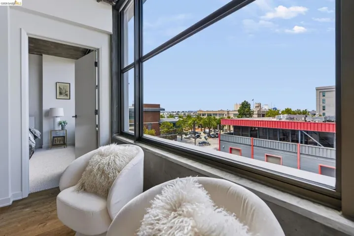 Expansive industrial-style windows frame urban surroundings and the Jack London waterfront