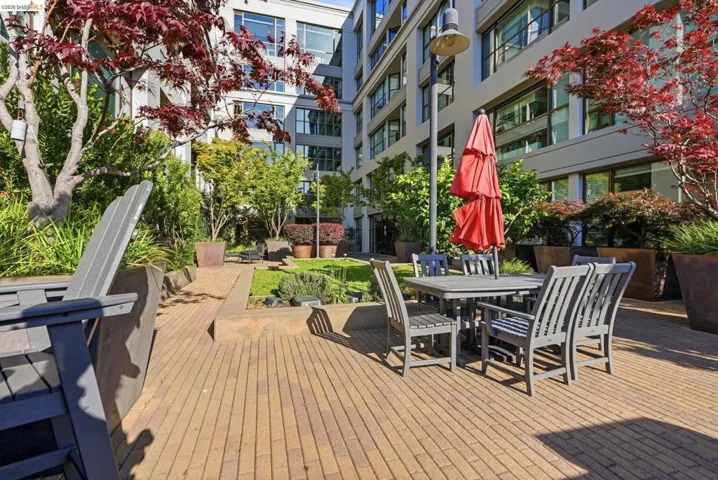 Private patio area featuring brick-patterned hardscaping and mature plantings
