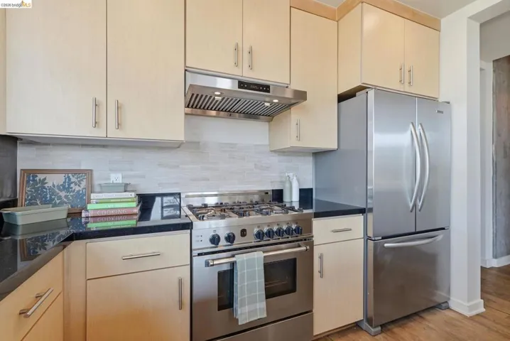 Contemporary kitchen featuring stainless steel appliances, including a range with a hood and a French-door refrigerator