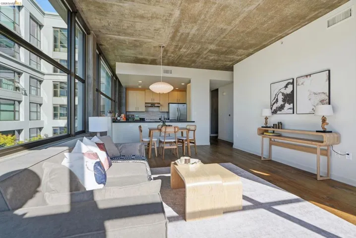 Open-concept living space featuring wood-finish flooring and a concrete ceiling