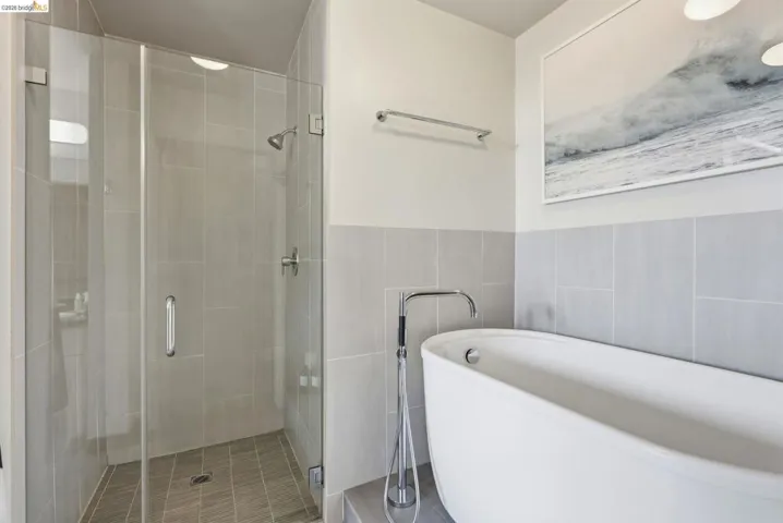 Modern bathroom featuring a freestanding soaking tub with a floor-mounted faucet