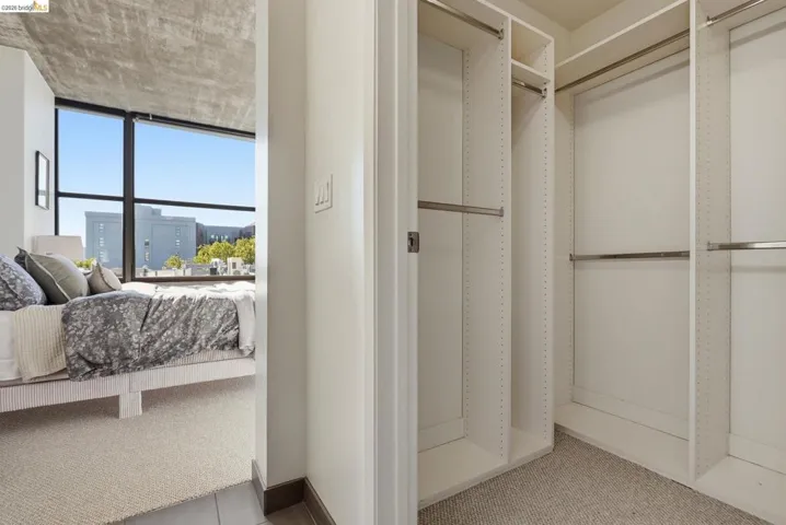 Custom closet organization system with multiple hanging rods, shelving, and neutral carpeting